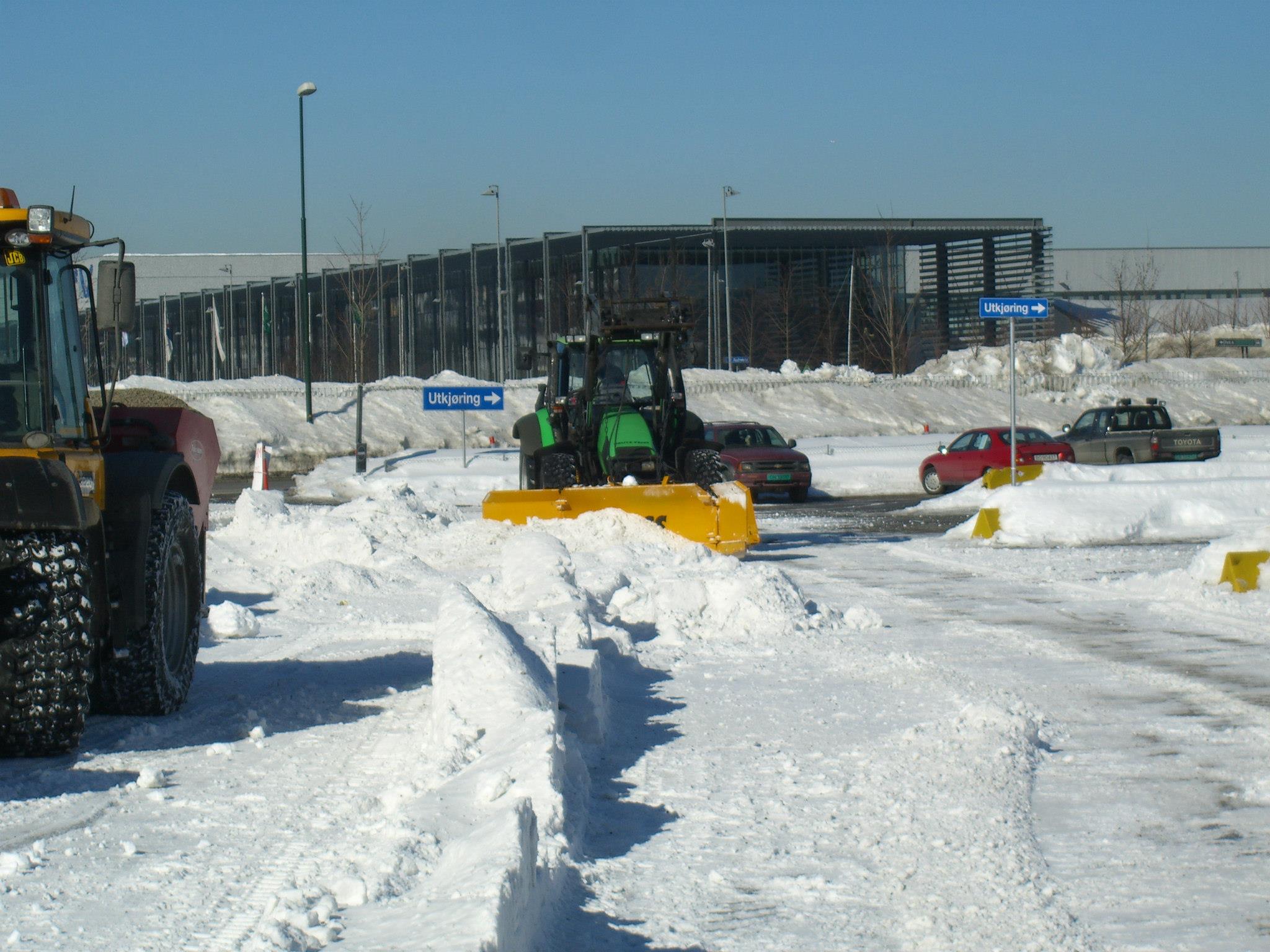 Bilde vis traktor med skjær som rydder snø