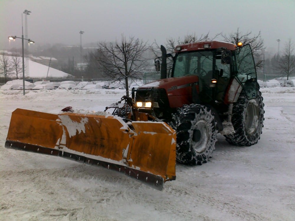 Bilde viser traktor med skjær som har brøytet snø